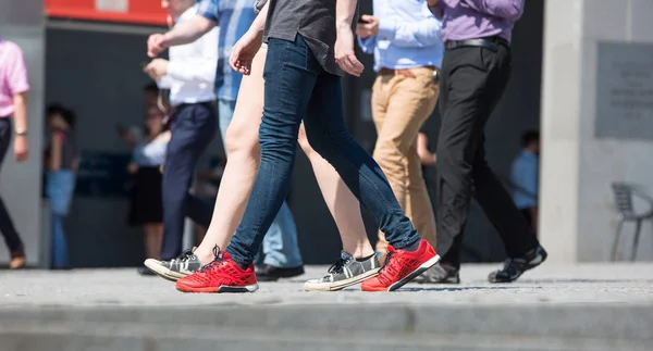 Feet of pedestrians walking on the crosswalk in Oxford street, London. Modern life, travel and shopping concept