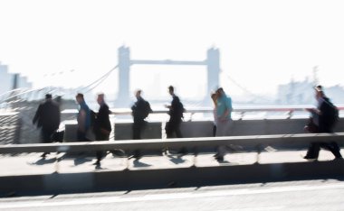 Londra, İngiltere - 19 Nisan 2018: Avrupa'nın önde gelen iş ve finans bölgesi Londra'ya giderken sabahın erken saatlerinde Londra köprüsünden geçen ofis çalışanlarının bulanık görüntüsü. Yoğun çalışma saatleri