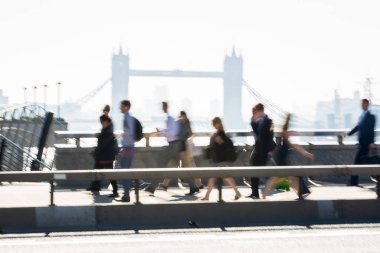 Londra, İngiltere - 19 Nisan 2018: Avrupa'nın önde gelen iş ve finans bölgesi Londra'ya giderken sabahın erken saatlerinde Londra köprüsünden geçen ofis çalışanlarının bulanık görüntüsü. Yoğun çalışma saatleri