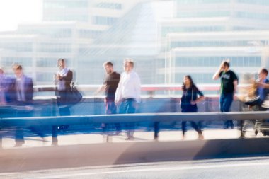 Londra, İngiltere - 19 Nisan 2018: Avrupa'nın önde gelen iş ve finans bölgesi Londra'ya giderken sabahın erken saatlerinde Londra köprüsünden geçen ofis çalışanlarının bulanık görüntüsü. Yoğun çalışma saatleri