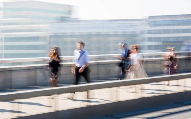 Londra, İngiltere - 19 Nisan 2018: Avrupa'nın önde gelen iş ve finans bölgesi Londra'ya giderken sabahın erken saatlerinde Londra köprüsünden geçen ofis çalışanlarının bulanık görüntüsü. Yoğun çalışma saatleri