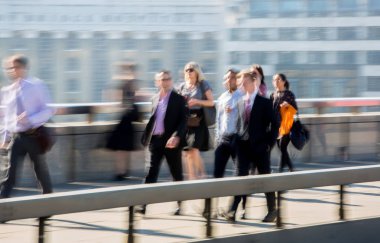 Londra, İngiltere - 19 Nisan 2018: Avrupa'nın önde gelen iş ve finans bölgesi Londra'ya giderken sabahın erken saatlerinde Londra köprüsünden geçen ofis çalışanlarının bulanık görüntüsü. Yoğun çalışma saatleri