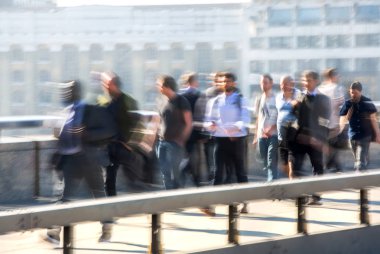 Londra, İngiltere - 19 Nisan 2018: Avrupa'nın önde gelen iş ve finans bölgesi Londra'ya giderken sabahın erken saatlerinde Londra köprüsünden geçen ofis çalışanlarının bulanık görüntüsü. Yoğun çalışma saatleri