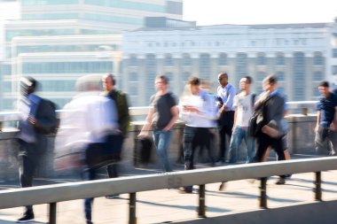 Londra, İngiltere - 19 Nisan 2018: Avrupa'nın önde gelen iş ve finans bölgesi Londra'ya giderken sabahın erken saatlerinde Londra köprüsünden geçen ofis çalışanlarının bulanık görüntüsü. Yoğun çalışma saatleri
