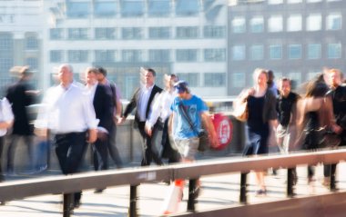 Londra, İngiltere - 19 Nisan 2018: Avrupa'nın önde gelen iş ve finans bölgesi Londra'ya giderken sabahın erken saatlerinde Londra köprüsünden geçen ofis çalışanlarının bulanık görüntüsü. Yoğun çalışma saatleri