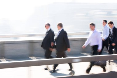 Londra, İngiltere - 19 Nisan 2018: Avrupa'nın önde gelen iş ve finans bölgesi Londra'ya giderken sabahın erken saatlerinde Londra köprüsünden geçen ofis çalışanlarının bulanık görüntüsü. Yoğun çalışma saatleri