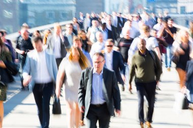 London, UK - April 19, 2018: Blurred image of office workers crossing the London bridge in early morning on the way to the City of London, the leading business and financial area in Europe. Rush hours clipart