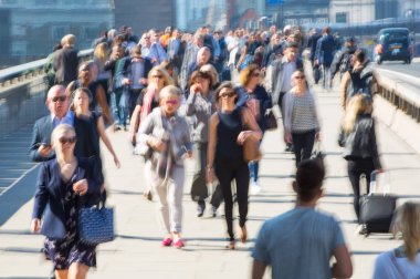 Londra, İngiltere - 19 Nisan 2018: Avrupa'nın önde gelen iş ve finans bölgesi Londra'ya giderken sabahın erken saatlerinde Londra köprüsünden geçen ofis çalışanlarının bulanık görüntüsü. Yoğun çalışma saatleri