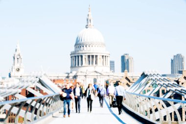 Londra, İngiltere - 19 Nisan 2019: Avrupa'nın önde gelen iş ve finans bölgesi Londra'ya giderken sabahın erken saatlerinde Milenyum köprüsünden geçen ofis çalışanlarının bulanık görüntüsü. Yoğun çalışma saatleri