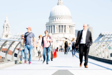 Londra, İngiltere - 19 Nisan 2019: Avrupa'nın önde gelen iş ve finans bölgesi Londra'ya giderken sabahın erken saatlerinde Milenyum köprüsünden geçen ofis çalışanlarının bulanık görüntüsü. Yoğun çalışma saatleri