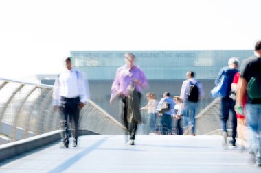 Londra, İngiltere - 19 Nisan 2018: Avrupa'nın önde gelen iş ve finans bölgesi Londra'ya giderken sabahın erken saatlerinde Londra köprüsünden geçen ofis çalışanlarının bulanık görüntüsü. Yoğun çalışma saatleri