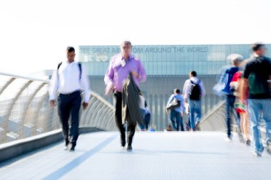 Londra, İngiltere - 19 Nisan 2018: Avrupa'nın önde gelen iş ve finans bölgesi Londra'ya giderken sabahın erken saatlerinde Londra köprüsünden geçen ofis çalışanlarının bulanık görüntüsü. Yoğun çalışma saatleri