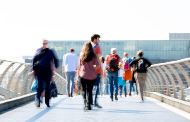 Londra, İngiltere - 19 Nisan 2018: Avrupa'nın önde gelen iş ve finans bölgesi Londra'ya giderken sabahın erken saatlerinde Londra köprüsünden geçen ofis çalışanlarının bulanık görüntüsü. Yoğun çalışma saatleri