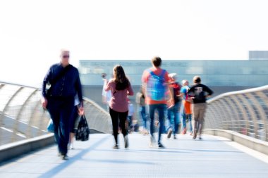 Londra, İngiltere - 19 Nisan 2018: Avrupa'nın önde gelen iş ve finans bölgesi Londra'ya giderken sabahın erken saatlerinde Londra köprüsünden geçen ofis çalışanlarının bulanık görüntüsü. Yoğun çalışma saatleri