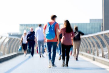 Londra, İngiltere - 19 Nisan 2018: Avrupa'nın önde gelen iş ve finans bölgesi Londra'ya giderken sabahın erken saatlerinde Londra köprüsünden geçen ofis çalışanlarının bulanık görüntüsü. Yoğun çalışma saatleri