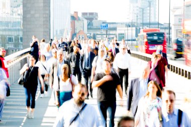 Londra, İngiltere - 19 Nisan 2018: Avrupa'nın önde gelen iş ve finans bölgesi Londra'ya giderken sabahın erken saatlerinde Londra köprüsünden geçen ofis çalışanlarının bulanık görüntüsü. Yoğun çalışma saatleri