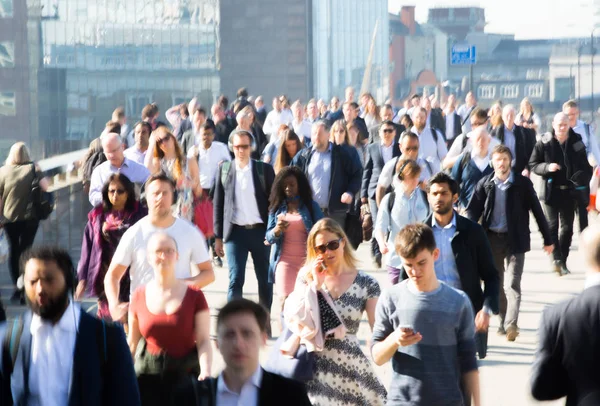 Londra, İngiltere - 19 Nisan 2018: Avrupa'nın önde gelen iş ve finans bölgesi Londra'ya giderken sabahın erken saatlerinde Londra köprüsünden geçen ofis çalışanlarının bulanık görüntüsü. Yoğun çalışma saatleri