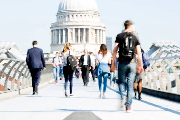 Londra, İngiltere - 19 Nisan 2019: Avrupa'nın önde gelen iş ve finans bölgesi Londra'ya giderken sabahın erken saatlerinde Milenyum köprüsünden geçen ofis çalışanlarının bulanık görüntüsü. Yoğun çalışma saatleri