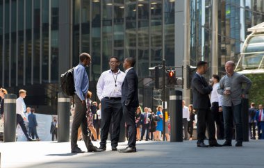 Londra, İngiltere - 26 Haziran 2019: Londra 'da öğle yemeği sırasında Lloyds binasının yanında yürüyen işadamları ve işadamları