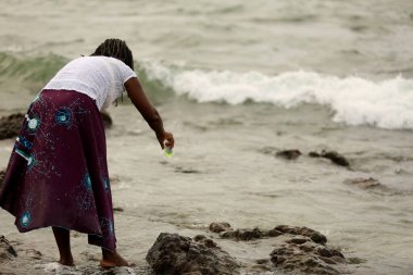Salvador, Bahia / Brezilya - 2 Şubat 2020: Dinsel kutlama sırasında Salvador 'da Rio Vermelho plajındaki orixa' ya parfüm sunan Yemanja 'nın candomble varlığı görülüyor.. 