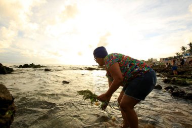Salvador, Bahia / Brezilya - 2 Şubat 2020: Salvador 'da dini kutlamalar sırasında Salvador şehrinde rio Vermelho plajında orixa çiçeği sunan Yemanja adlı candomble varlık görülüyor.. 