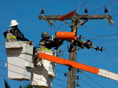 prado, bahia / brazil - december 9, 2009: electricians are seen making repairs to a utility pole in the city of Prado.