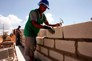 porto seguro, bahia / brazil - april 18, 2010: masons are seen working on the construction of popular houses in a Ferderal Government project in the city of Porto Seguro. 
