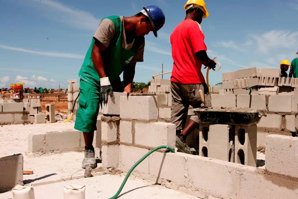 porto seguro, bahia / brazil - april 18, 2010: masons are seen working on the construction of popular houses in a Ferderal Government project in the city of Porto Seguro. 