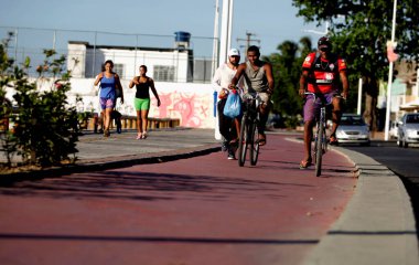 Salvador, Bahia / Brezilya - 2 Aralık 2015: Salvador 'un Ribeira semtinde Avenida Beira Mar' da bisiklet yolunda bisikletçi. 