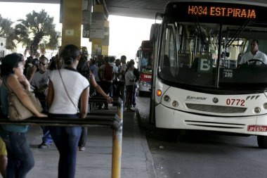 Salvador, Bahia / Brezilya - 4 Nisan 2013: Yolcular Salvador kentindeki Estacao Piraja 'da toplu taşıma otobüslerine binmek için sırada görülmektedir..