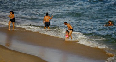 Salvador, Bahia / Brezilya - 22 Ağustos 2014: Salvadorlu Salvador 'daki plajda Barra sahilinde banyo yapan insanlar görülüyor..