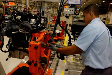 Camacari, Bahia / Brezilya - 9 Nisan 2014: Camacari şehrinin sanayi kutbunda Ford fabrikasının motor montaj hattı üzerinde çalışan işçi.