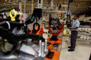 Camacari, Bahia / Brezilya - 9 Nisan 2014: Camacari şehrinin sanayi kutbunda Ford fabrikasının motor montaj hattı üzerinde çalışan işçi.