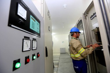 Lauro de Freitas, Bahia / Brezilya - 10 Ağustos 2016: Teknisyen, Lauro de Freitas kentindeki Itinga mahallesindeki Coelba alt istasyonunda elektrik panellerini gözlemlemektedir.. 