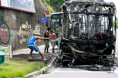 Salvador, Bahia / Brezilya - 25 Aralık 2014: İnsanlar Salvador şehrindeki yanan araçtan bir otobüs parçası topluyor..
