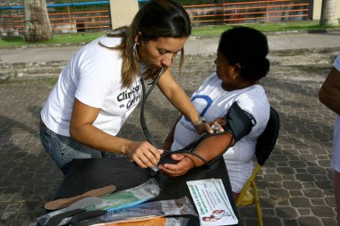 Itabuna, Bahia / Brezilya - 23 Mart 2012: Hemşirelik teknisyeni Itabuna şehrinde sosyal eylem sırasında kan basıncını ölçtü.