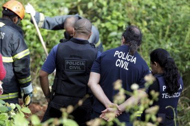Salvador, Bahia / Brezilya - 24 Ağustos 2015: Sivil polis müfettişleri Salvador şehrindeki çalılık alanda öldürülen birini araştırıyor..