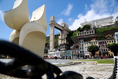 Salvador, Bahia / Brezilya - 21 Mart 2013: Mario Cravo 'nun Comercio mahallesindeki heykeli ve arka planda Salvador kentindeki Lacerda Asansörü.