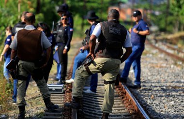 Salvador, Bahia / Brezilya - 23 Kasım 2015: Sivil polis müfettişleri Salvador 'daki banliyö tren hattı yakınlarında öldürülen kişiyi araştırıyor..