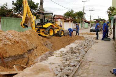Eunapolis, Bahia / Brezilya - 17 Kasım 2010: kepçe makinesi Bahia 'nın güneyindeki Eunapolis şehrinde bir caddede bir kanalizasyon ağının uygulanması üzerinde çalışıyor.