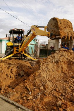 Eunapolis, Bahia / Brezilya - 17 Kasım 2010: kepçe makinesi Bahia 'nın güneyindeki Eunapolis şehrinde bir caddede bir kanalizasyon ağının uygulanması üzerinde çalışıyor.
