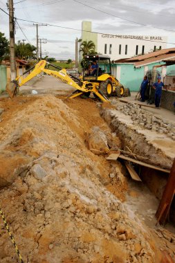 Eunapolis, Bahia / Brezilya - 17 Kasım 2010: kepçe makinesi Bahia 'nın güneyindeki Eunapolis şehrinde bir caddede bir kanalizasyon ağının uygulanması üzerinde çalışıyor.