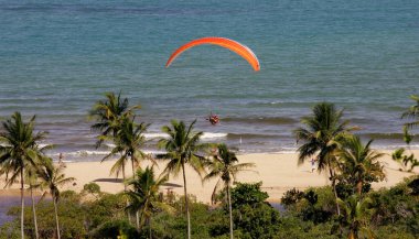 Porto seguro, bahia, / brrazil - 30 Eylül 2014: Bahia 'nın güneyindeki Porto Seguro şehrinde Trancoso bölgesinin gökyüzünde bir paraşütçüyü uçuran insanlar görülüyor..