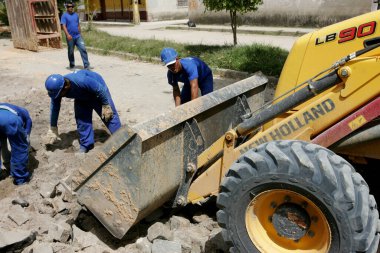 Eunapolis, Bahia / Brezilya - 17 Kasım 2010: kepçe makinesi Bahia 'nın güneyindeki Eunapolis şehrinde bir caddede bir kanalizasyon ağının uygulanması üzerinde çalışıyor.