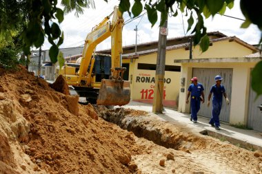 Eunapolis, Bahia / Brezilya - 17 Kasım 2010: kepçe makinesi Bahia 'nın güneyindeki Eunapolis şehrinde bir caddede bir kanalizasyon ağının uygulanması üzerinde çalışıyor.