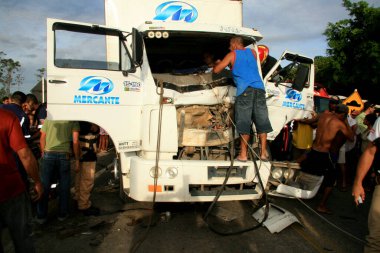Eunapolis, Bahia / Brezilya - 28 Ocak 2009: Güney Bahia 'daki Eunapolis şehrinde BR 101 karayolunda bir kaza sırasında donanımda mahsur kalan bir kamyon şoförünü kurtarmaya gelen insanlar.