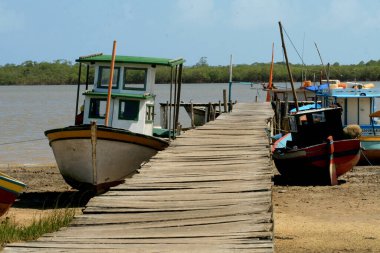 Caravelas, Bahia / Brezilya - 12 Ocak 2009: Bahia 'nın güneyindeki Caravelas şehrindeki Caravelas Nehri' ndeki balıkçı tekneleri limanına ulaşmak için ahşap iskele