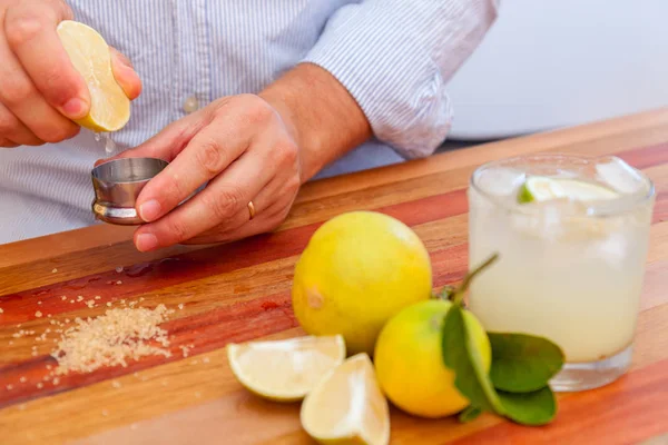 Der Barkeeper macht Margaritas aus mexikanischem Kalk. Alkoholischer Cocktail serviert ein Messglas — Stockfoto