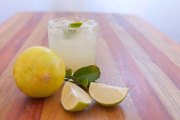 Key lime margarita gegarneerd met verse limoen in een glazen bar tafel — Stockfoto