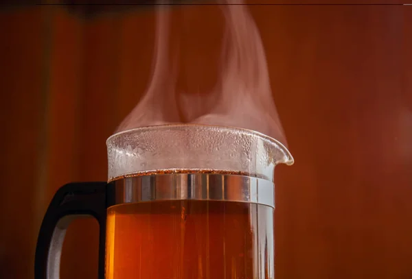 Svart te i glas vattenkokare fraktandet — Stockfoto